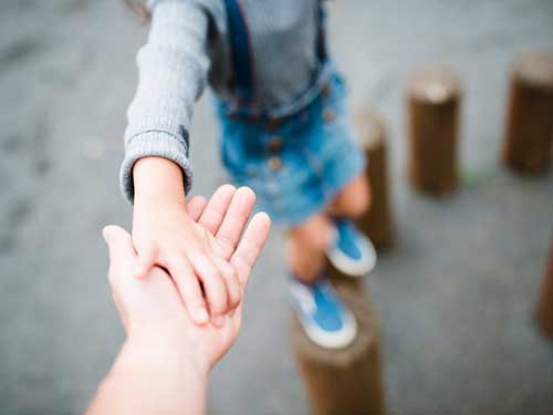 Parent holding child’s hand – family law FAQs and support for parents.