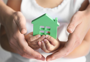 Family holding a toy house – common family law issues about shared care and child arrangements.