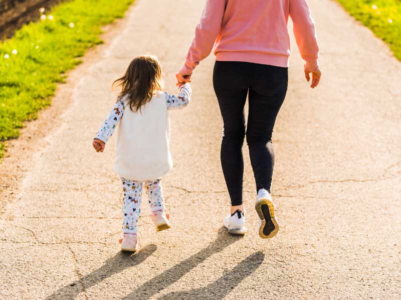 Mother and child walking together outdoors – family law appointments and child-focused legal support.