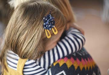 Young girl hugging her mother – common family law issues including child contact and emotional wellbeing.